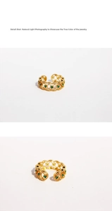 Macro shot of the luxury emerald green gemstone and hollow gold-plated ring band