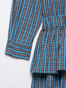 Détail de la robe à carreaux bleu et marron avec taille élastique et boutons métalliques
