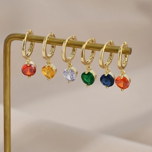 Set of six colorful zircon drop earrings in gold finish hanging on a metal display stand