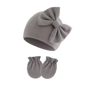 Close-up of gray ribbed knit baby beanie with a large bow and matching anti-scratch mittens