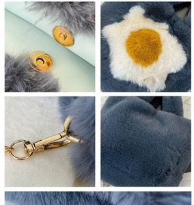 Detail of blue plush handbag with flower pattern and magnetic metal buckle closure