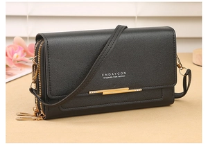 Detail of black PU leather crossbody bag with lychee texture and gold-tone zippers