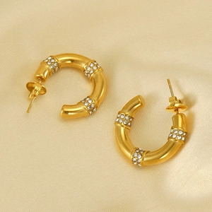 Boucles d'oreilles C dorées en forme de bambou avec cristaux sur satin champagne