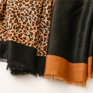 Detail of leopard print scarf featuring gold foil threads and elegant tassel fringe