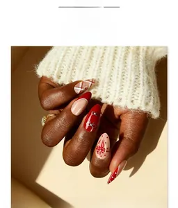 Macro shot of red and white almond press-on nails with bow and polka dot patterns