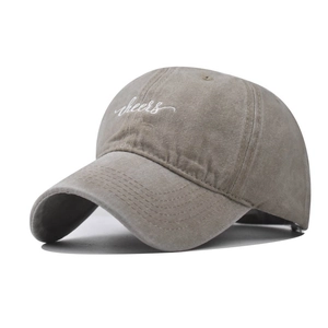 Close-up of white Cheers embroidery on vintage khaki washed cotton baseball cap