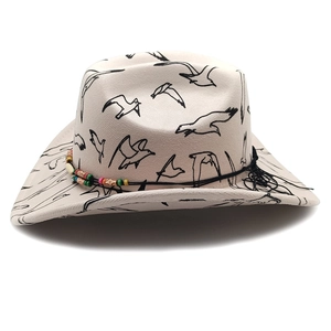 Detail of beige felt cowboy hat with seagull print and colorful ethnic bead band