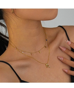 Detail of gold Scorpio zodiac necklace with rainbow colored square cut cubic zirconia