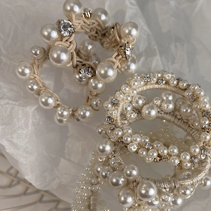 Detail shot of pearl and rhinestone hair ties with fabric textures and golden accents
