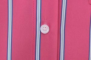 Macro detail of pink vertical striped shirt fabric with a white four-hole resin button