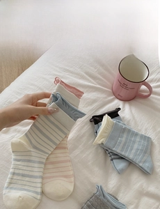 Close-up of striped cotton socks with delicate lettuce trim and soft knitted texture