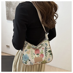 Detail of floral tapestry bag featuring vintage botanical embroidery and leather logo patch