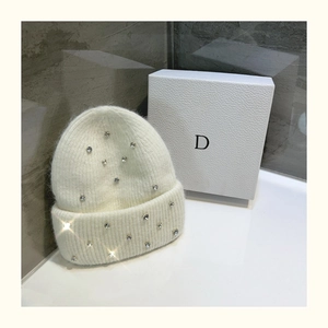Detailed texture of white knit beanie with scattered rhinestones and fluffy angora fur