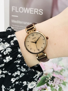 Close-up of elegant GEDI women watch with brown leather strap and gold case on wrist