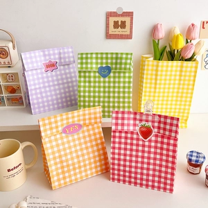 Colorful gingham kraft paper gift bags with decorative cartoon stickers in various bright hues