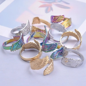 Macro view of adjustable stainless steel wing rings in gold, silver, and iridescent finishes