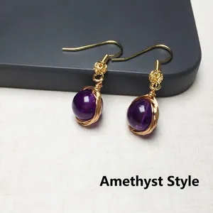 Vue détaillée macro de boucles d'oreilles en améthyste avec fil d'or 14K enveloppé