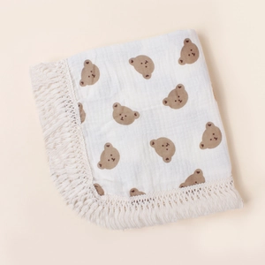 Detailed shot of soft cotton baby blanket with brown bear prints and delicate lace edges