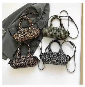 Flat lay of vintage PU leather Boston bags in leopard print and green houndstooth patterns