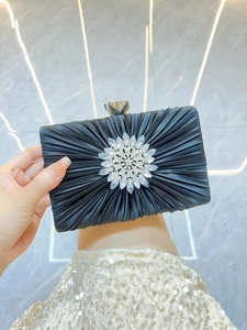 Details einer schwarzen Seiden-Abendtasche mit großer Strass-Sonnenblume und Kristallverschluss