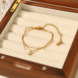 Elegant multi-strand gold titanium necklace with a natural freshwater pearl in a jewelry box
