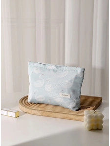 Blue canvas swan jacquard makeup bag for travel storage displayed with accessories