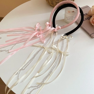 Detail of sweet fabric bow headbands with long ribbon tassels and pearly bead chains