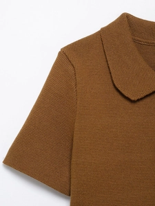 Detail of a brown knit top showing the refined texture and peter pan collar design