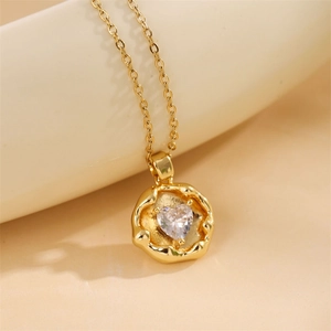 Macro shot of gold heart necklace with zircon inlay on a minimalist curved prop