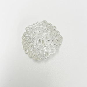 Close-up of matte silver hair clip featuring a delicate hollow floral metal design