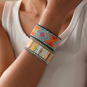 Close-up of bohemian leather beaded bracelet with colorful geometric patterns on model arm