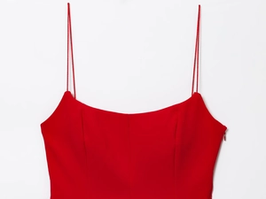 Detail of red camisole top featuring thin straps and structured chest seam construction