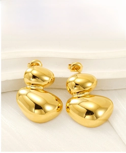 Vue détaillée des boucles d'oreilles ovales géométriques dorées avec fini miroir poli