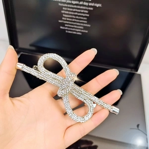 Dettaglio della molletta a fiocco con strass scintillanti in una confezione regalo