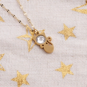 Macro shot of gold cat pendant necklace featuring a sparkling round clear gemstone inlay