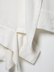 Macro shot of white satin fabric showing high-quality stitching and textured layered design