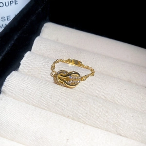Close-up of a gold horseshoe buckle chain ring with sparkling cubic zirconia inlay