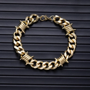 Detail of golden hip hop Cuban link bracelet featuring unique thorn wire design elements