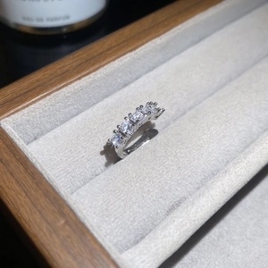 Gros plan d'une bague d'oreille en argent avec cinq zircons étincelants et perles