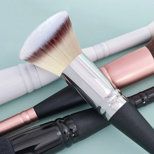 Dual-head makeup brush set with foundation and concealer tools on blue background