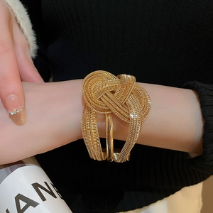 Detailed view of the layered gold mesh knot bracelet featuring a high-fashion industrial design