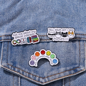 Three colorful enamel pins with quotes on a denim jacket showing a stylish collection