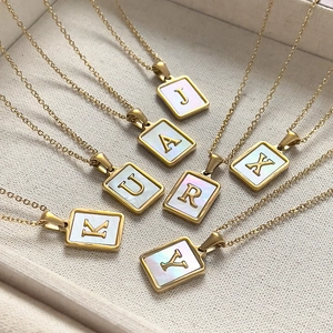 18K gold stainless steel necklaces with initial pendants and white shell inlay in a jewelry box