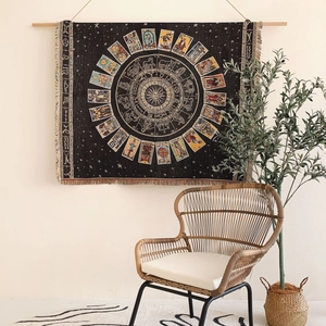 Bohemian tarot zodiac woven tapestry with fringe hanging on wall in cozy home setting