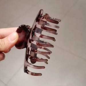 Close-up of a large dark tortoiseshell hair claw clip with purple-brown gradient finish