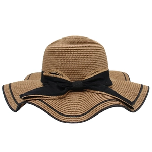 Elegant wide brim straw hat with black bow ribbon and scalloped edges for sun protection