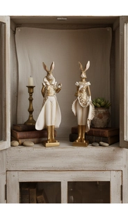 Detailed view of vintage resin rabbit figurines with Victorian lace and golden boots