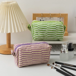 Detailed knit texture of green and purple checkered makeup bags with sturdy side handles