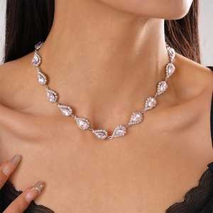 Close-up of pink teardrop crystal necklace with silver diamond accents on model