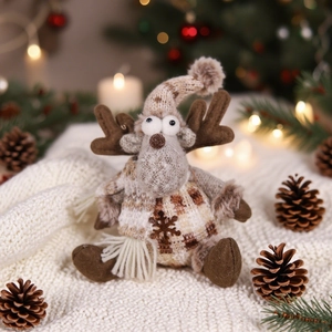 Close-up of knit reindeer plush in checkered sweater with warm Christmas tree background